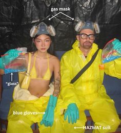 a man and woman sitting on top of a couch wearing yellow suits with gas masks