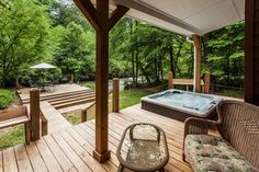 a hot tub sitting on top of a wooden deck next to a covered patio area