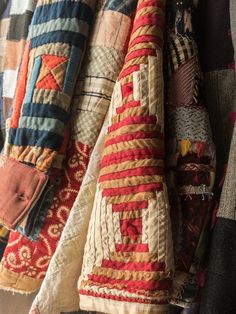 many different colored pieces of fabric hanging on a wall