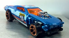a blue toy car with orange rims and engine on the front wheel drive wheels