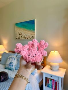 a person holding up a pink stuffed animal