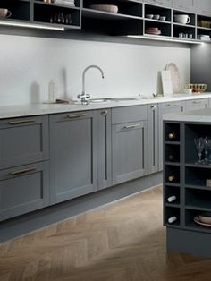 a large kitchen with gray cabinets and white counter tops is seen in this image from the front view
