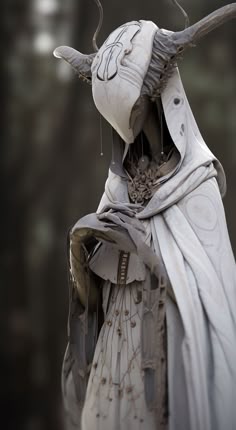 a statue is dressed in white with horns