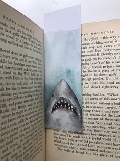 an open book with a drawing of a shark's mouth on the pages and inside