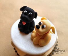 two cupcakes that have been decorated to look like dogs sitting on top of each other