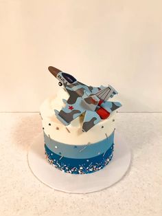 a blue and white cake with an airplane on top