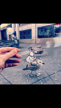 a hand holding up a sticker with a bird on it