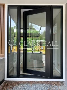 an open black double door on the side of a building with glass and wood doors