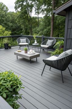 an outdoor deck with chairs, tables and coffee table in the center is surrounded by greenery