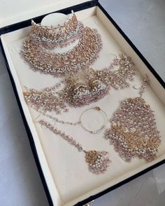 an open box with several necklaces and bracelets in it