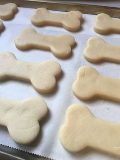 dog bone shaped cookies sitting on top of a cookie sheet