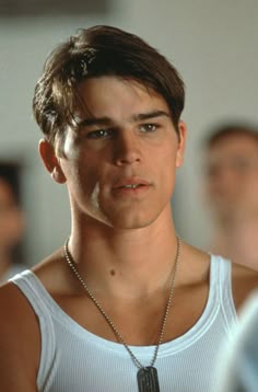 the young man is wearing a silver necklace