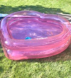 an inflatable heart shaped swimming pool on the grass