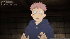 a man with pink hair wearing a blue hoodie in front of a brick wall