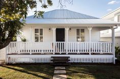 a white house sitting on top of a lush green field