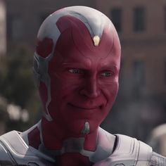 a close up of a person wearing a red and white suit with gold accents on his face