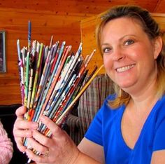 a woman holding a bunch of pencils in her hands