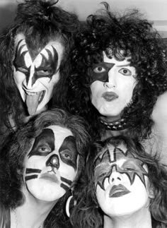 four people with their faces painted in black and white