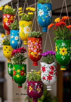 many colorful flower pots hanging from strings