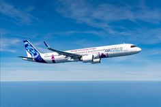 an airplane is flying in the sky above the ocean and blue skies with white clouds