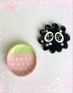 a black and pink object sitting on top of a table next to a green ball