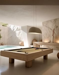 a pool table in the middle of a room next to a wall with lights on it