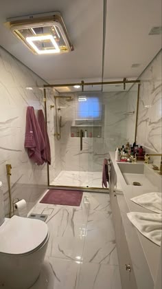 a bathroom with a toilet, sink and shower stall is shown in white marbled finish