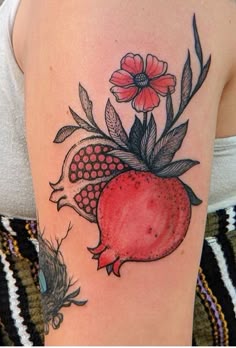 a woman with a tattoo on her arm has a pomegranate and flowers