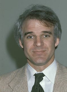 a man with grey hair wearing a suit and tie