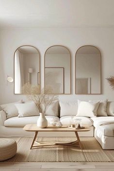 a living room filled with white furniture and mirrors
