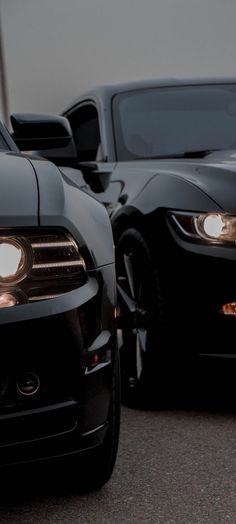 two black sports cars parked next to each other
