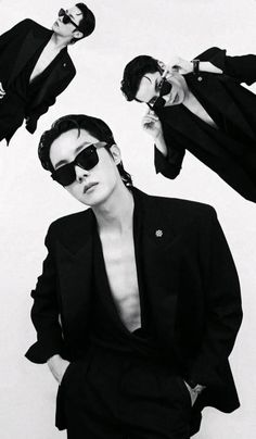 two men in black suits and sunglasses are posing for the camera with their hands on their hips