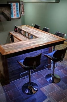 a kitchen table with two stools in front of it and a bar on the other side