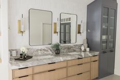 a bathroom with double sinks and two mirrors on the wall next to eachother