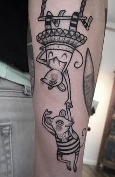 a man with a tattoo on his arm has an image of a cat and mouse