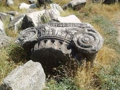 some rocks and grass in the middle of an area with many large rocks on it