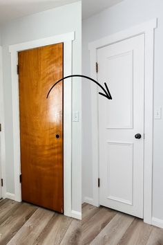 an arrow pointing to the left in front of a wooden door with two white doors