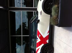 a mini car with the british flag painted on it parked in front of a building