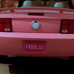 the back end of a pink car with a license plate that reads fabulus