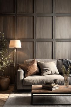 a living room with a couch, table and lamp on the side wall in front of wooden paneled walls