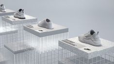 three pairs of white sneakers are on display