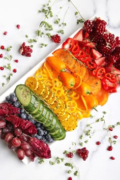 sliced fruits and vegetables arranged in a rainbow pattern
