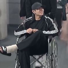 a man sitting in a wheel chair with his foot up on the leg of another person