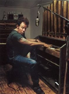 a man sitting at a piano in front of an old fashioned microphone and recording equipment