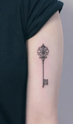 a small key tattoo on the left arm