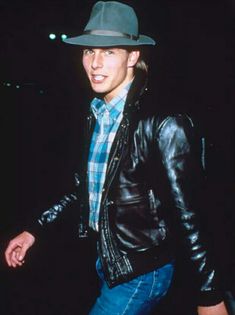 a young man wearing a hat and leather jacket