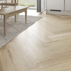 a wooden table sitting on top of a hard wood floor next to an open window