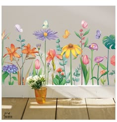 a wall with flowers painted on it and a potted plant in the foreground