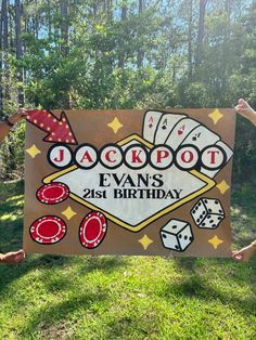 two children holding up a sign that says jackpot evans 21st birthday with playing cards and dice on it