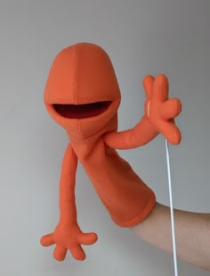 an orange stuffed animal holding a white stick